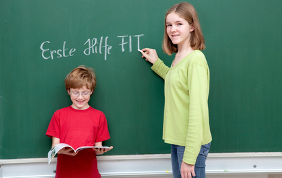 © ÖJRK/Nadja Meister Zwei Kinder schreiben "Erste Hilfe FIT" an die Tafel